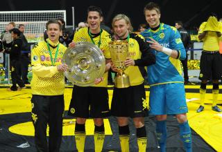 Stolz hat der ehemalige BVB-Spieler Chris Löwe (links) die Hand an der Meisterschale.
