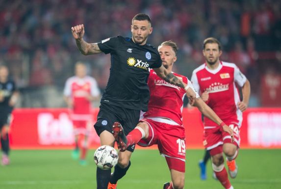 Unions Florian Hübner streckt sich zum Ball gegen Duisburgs Boris Tashchy.