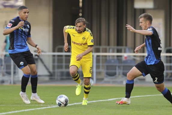 Marcel Schmelzer (Mitte) vom Bundesligisten Borussia Dortmund setzt sich gegen zwei Gegenspieler durch.